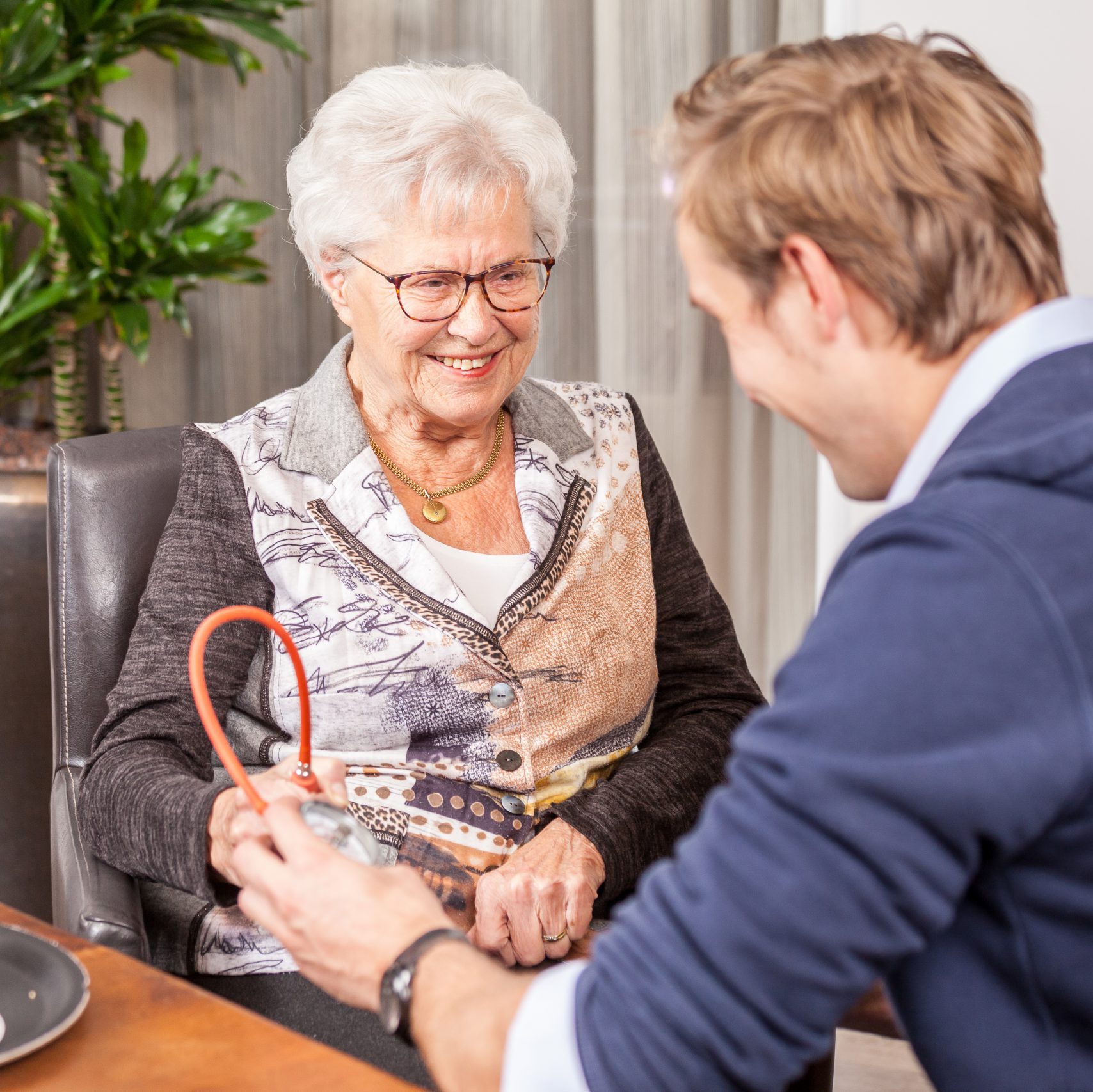 Oudere vrouw bij jonge fysio - FotoFluvius